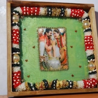 Square wooden frame with a preserved garland border and a wedding photo in green resin